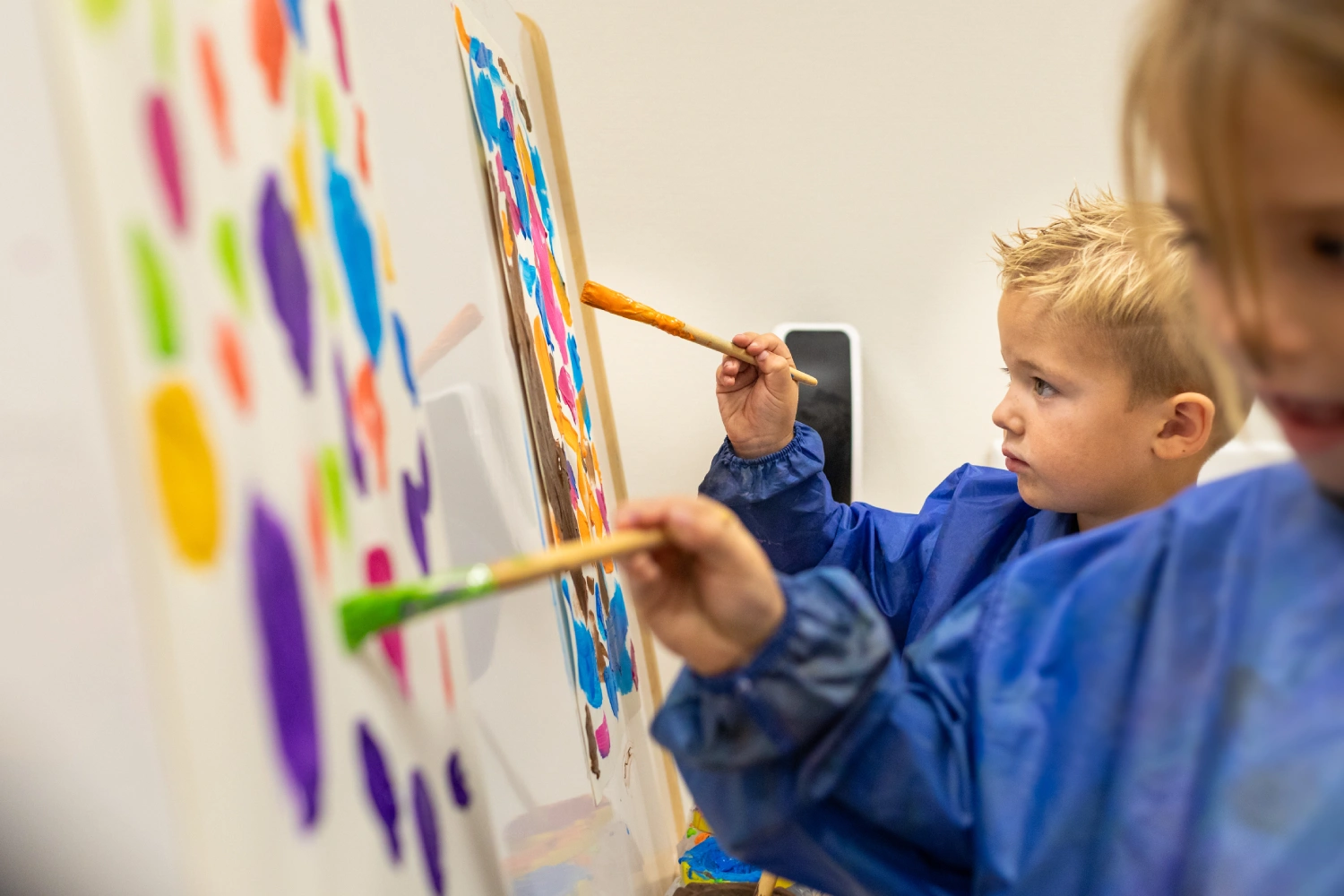 Detailfoto van kind dat schilderij maakt bij Kindcentrum T Veer